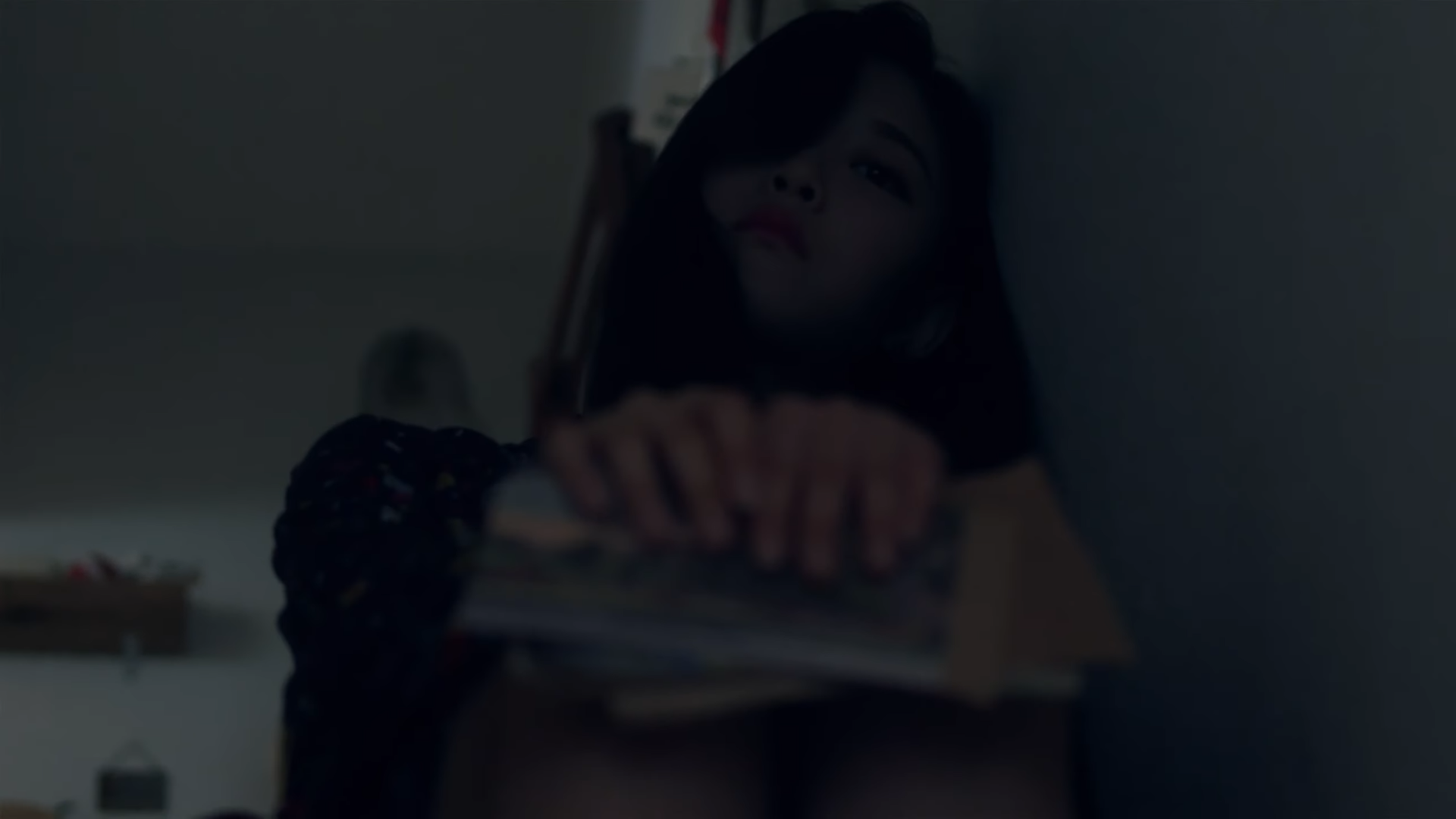 Hyunjin laying against the wall, looking sad.